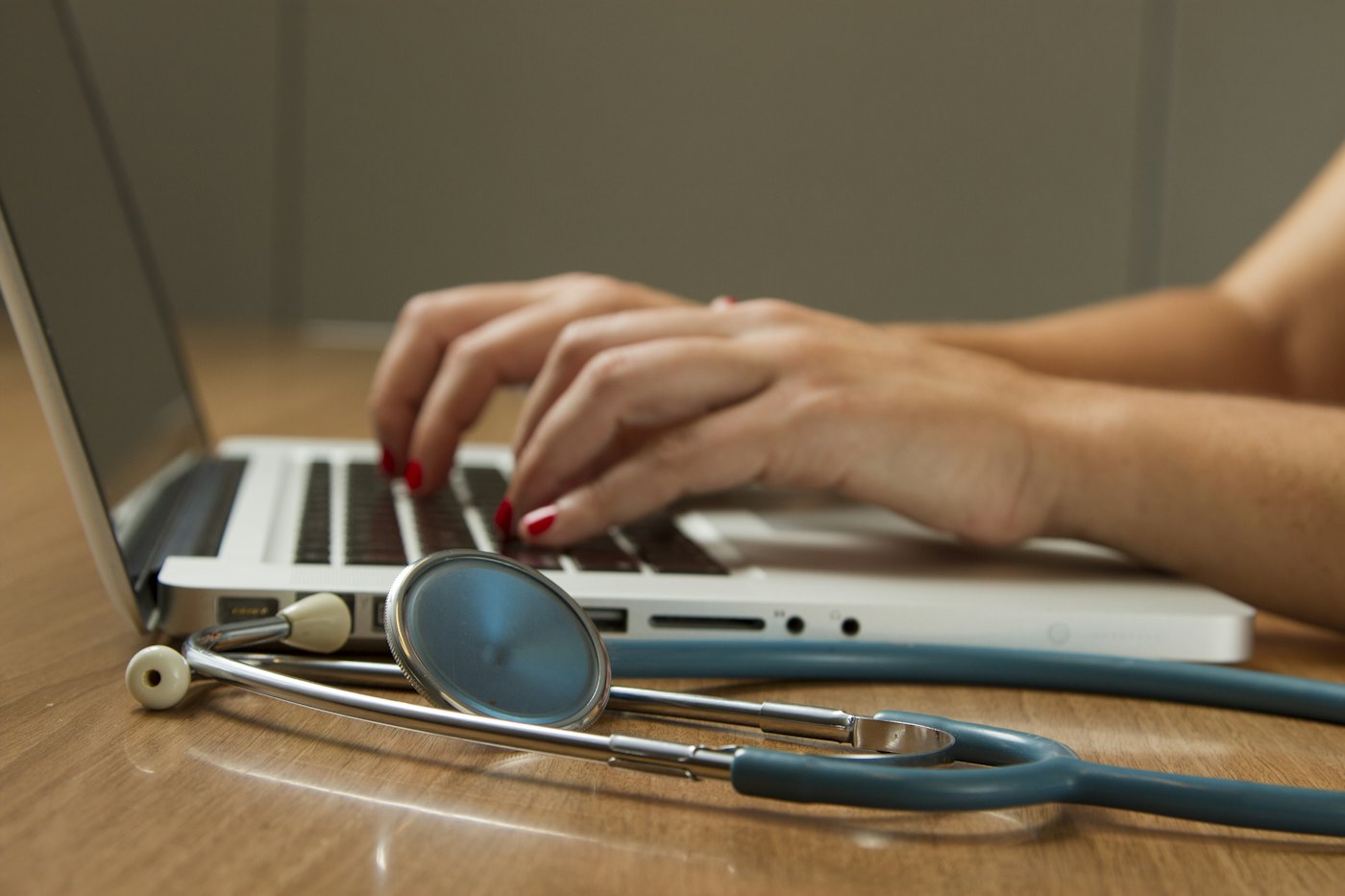 A laptop and a stethoscope on a desk